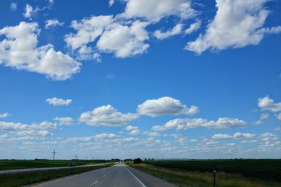 Road by landscape against blue sky