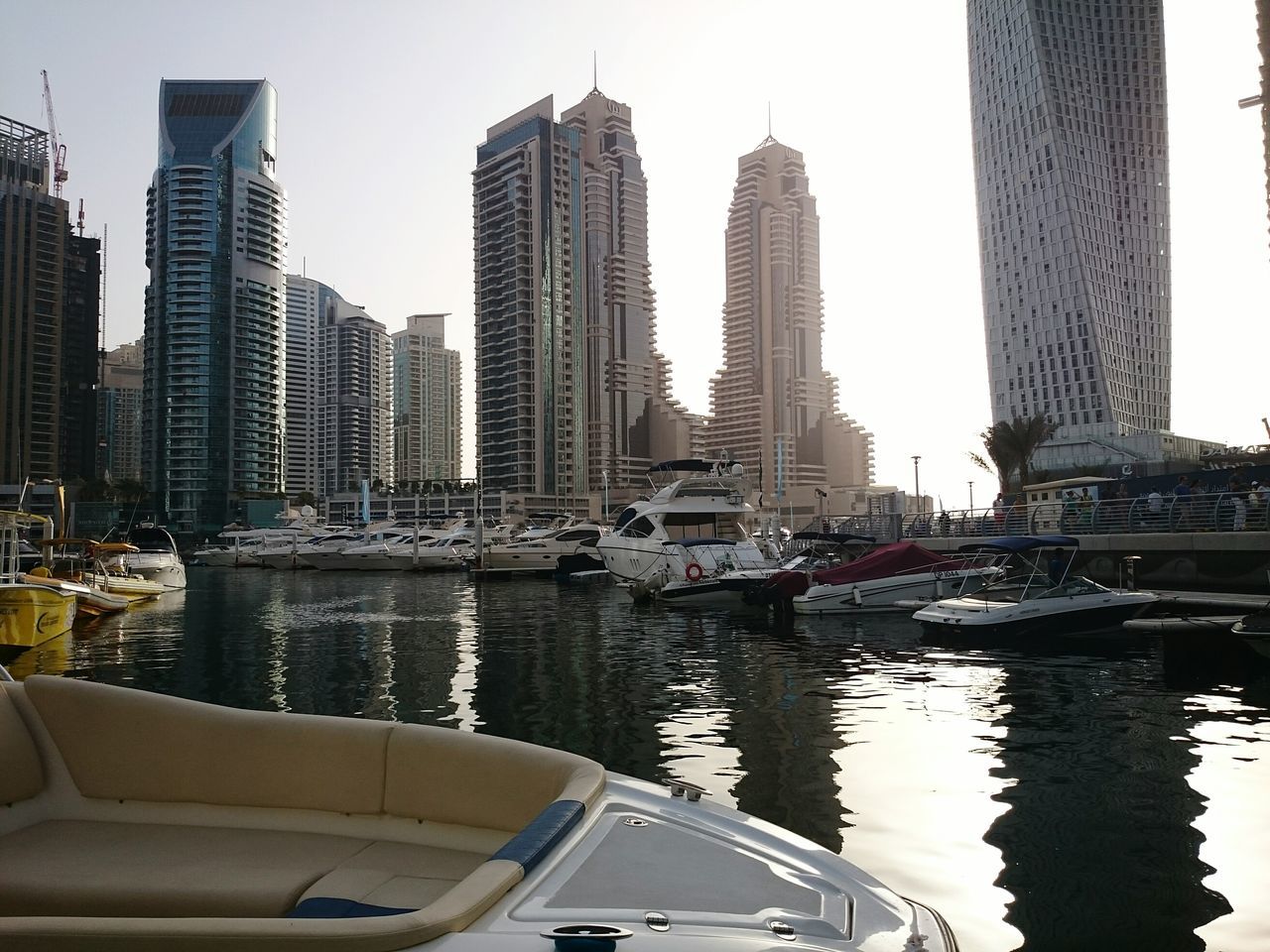 transportation, nautical vessel, mode of transport, building exterior, architecture, city, built structure, boat, water, moored, river, harbor, travel, clear sky, skyscraper, cityscape, tall - high, tower, car, city life