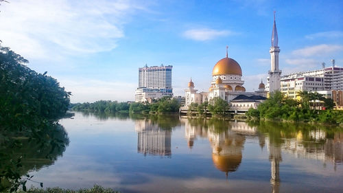 Reflection of buildings in lake against sky