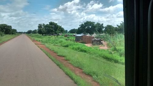 Road amidst green landscape against sky