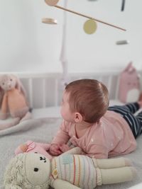 Baby girl lying on bed at home