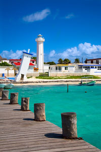 Pier over sea against buildings