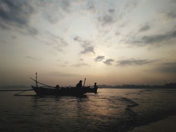 Silhouette boat in sea against sky during sunset