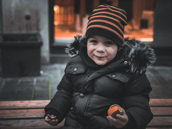 Portrait of smiling toddler standing in city