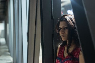 Portrait of woman looking through window