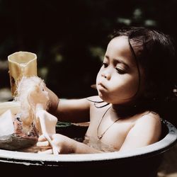 Close-up of cute girl bathing with barbie doll