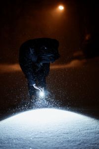 Close-up of illuminated snow against sky at night