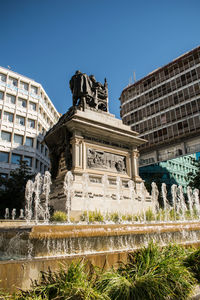 Statue of fountain in city against clear sky
