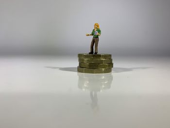 Close-up of figurine on table against white background
