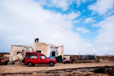 Cars on road against cloudy sky