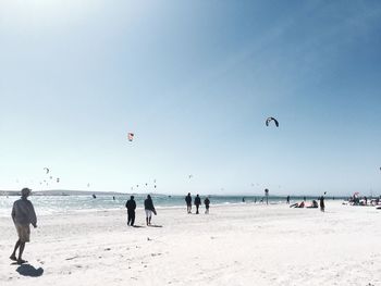 People at beach against sky