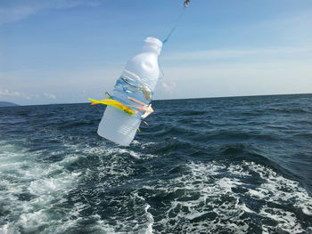 Man surfing in sea against sky