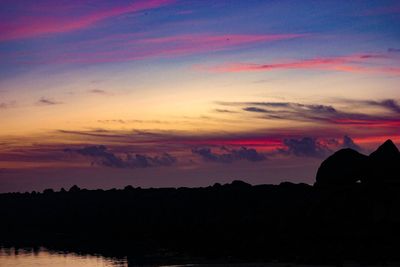 Scenic view of silhouette landscape against dramatic sky during sunset