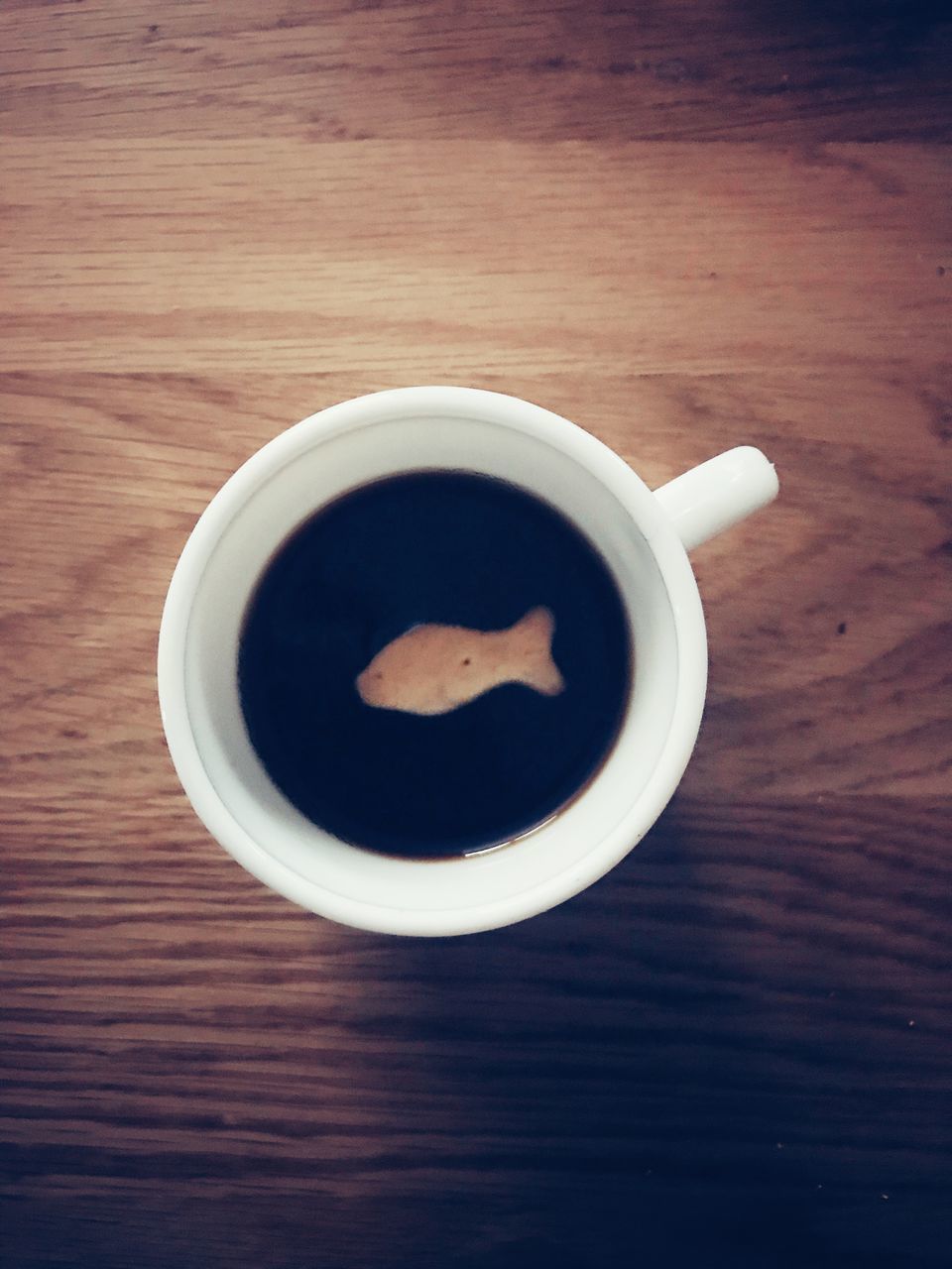 HIGH ANGLE VIEW OF COFFEE CUP ON WOODEN TABLE