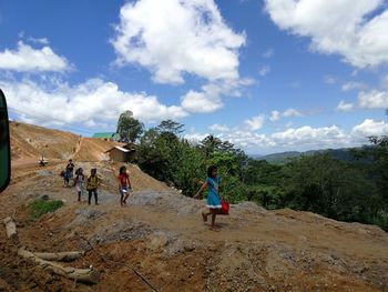 People on mountain road against sky