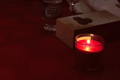 Close-up of illuminated tea light candle on table