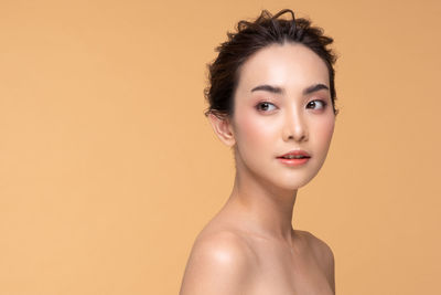 Portrait of young woman against gray background