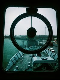 Close-up of boat against the sky seen through window