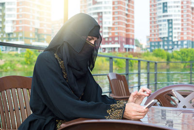 Rear view of woman sitting on chair