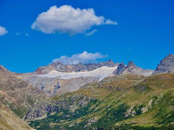 Scenic view of mountains against blue sky