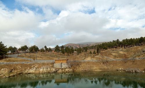 Scenic view of river against cloudy sky