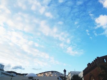 Low angle view of buildings against cloudy sky