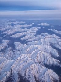 Aerial view of snowcapped mountains against sky