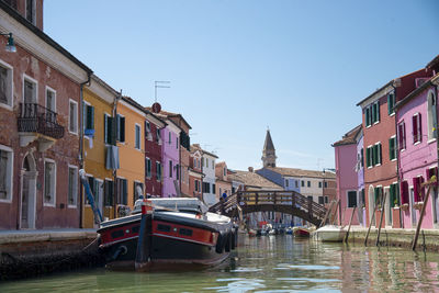 Boats moored in canal against buildings