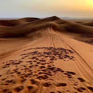 Sand dunes in desert against sky