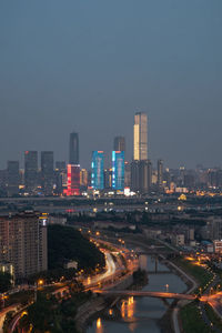 Illuminated buildings in city against sky