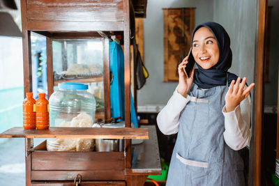 Portrait of young woman standing at home