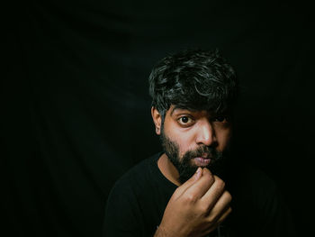 Portrait of man against black background