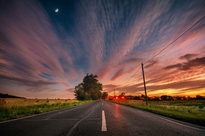 Country road against sky during sunset