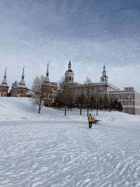 People in traditional building against sky during winter