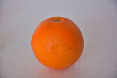 Close-up of orange apple against white background