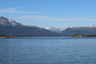 Scenic view of sea and mountains against blue sky