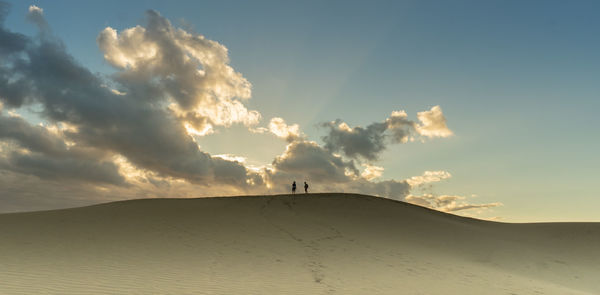 Scenic view of desert against sky during sunset