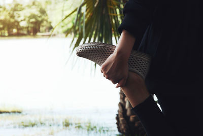 Midsection of woman exercising by pond