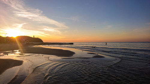 Scenic view of beach against sky during sunset