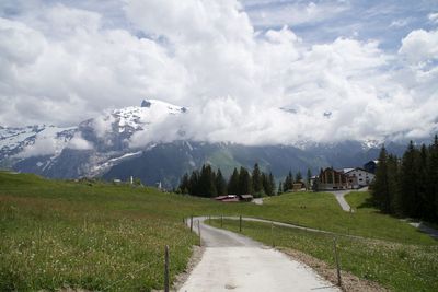 Road amidst green landscape against sky