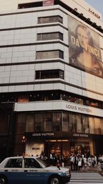 People on street against building in city