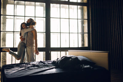 Young pretty couple having fun on bed in morning.