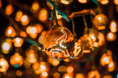 Close-up of christmas decoration against lights
