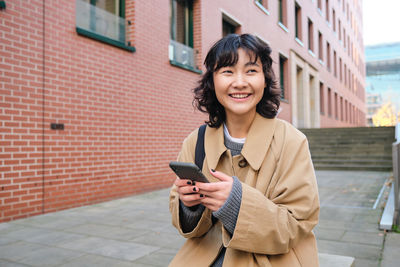 Portrait of young woman using mobile phone