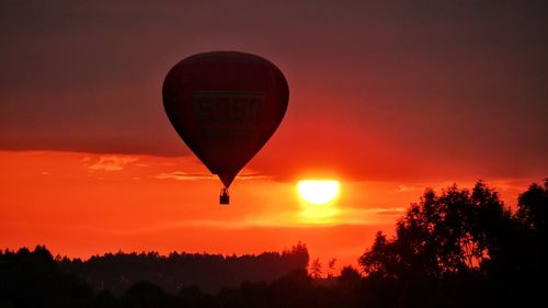 Silhouette hot air balloon against sky during sunset