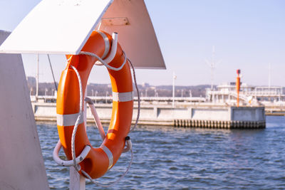 Orange lifebuoy on beach by sea. safety equipment for rescuing people on seashore. orange lifebuoy