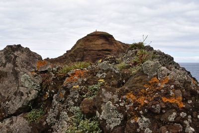 Rock formations in sea against sky