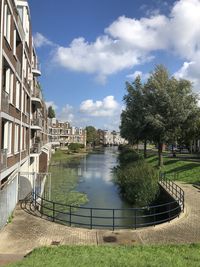 Canal amidst buildings against sky in city