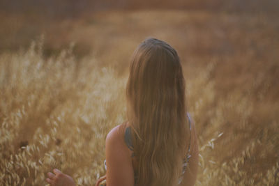 Rear view of woman standing on field