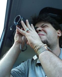 Close-up of man photographing through window